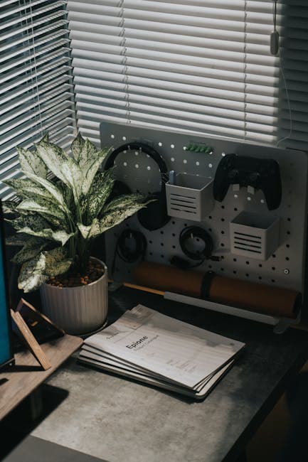 Stylish desk setup featuring a potted plant, gadgets, and accessories with natural lighting.
