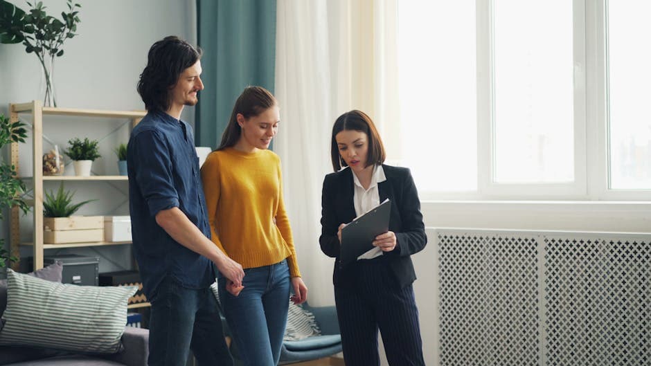 A young couple discusses home buying options with a real estate agent inside a well-lit modern room.