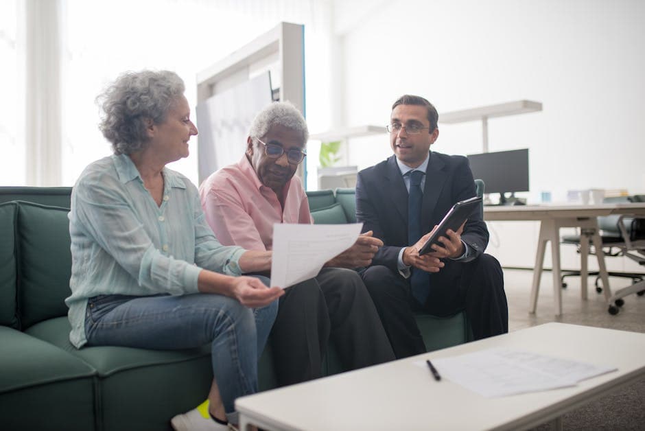 Senior couple discussing documents with a business advisor in a modern office setting.