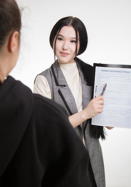 Young Asian businesswoman explaining home insurance policy to client, highlighting details with pen.