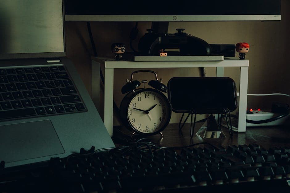 Tidy desk setup with a laptop, analog clock, and desk decor in a modern home workspace setting.