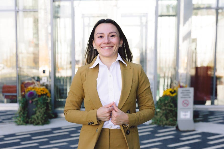 A professional woman in a business suit smiling confidently outside a modern building.