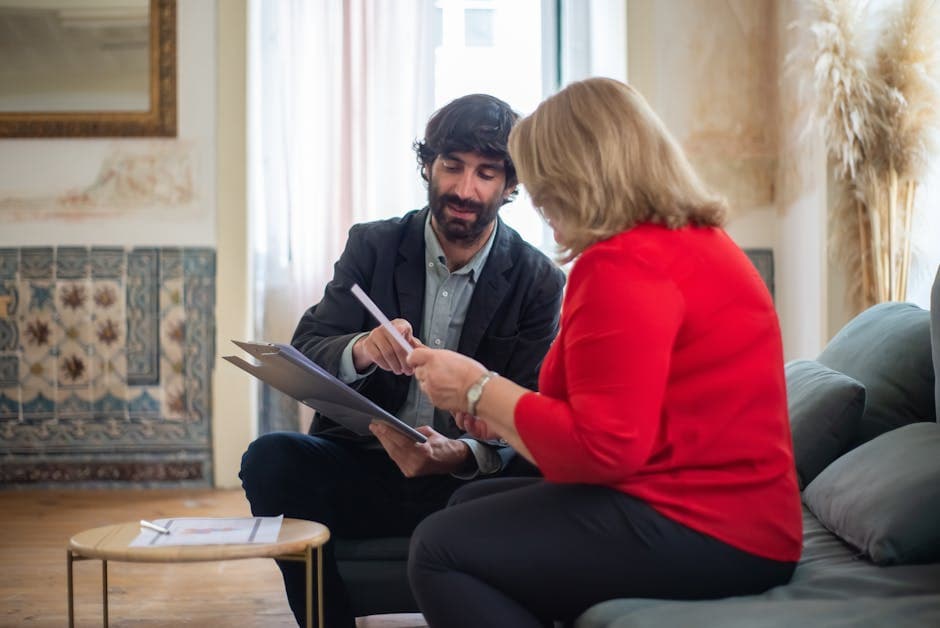A man and woman having a business discussion seated on a sofa in a stylish room.