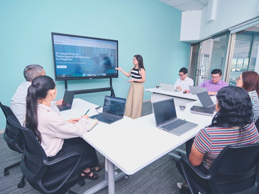 A diverse group in a collaborative meeting using a digital display in a modern office.