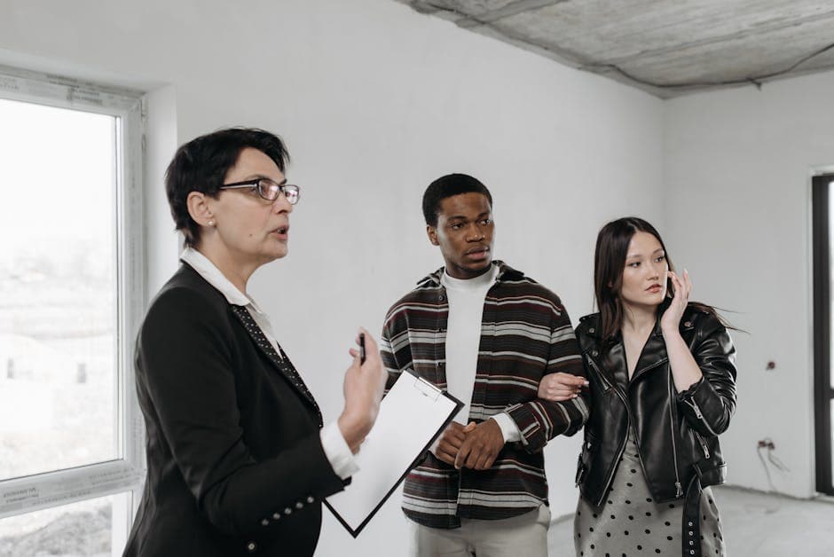 A realtor discusses property details with a diverse couple viewing a house interior.