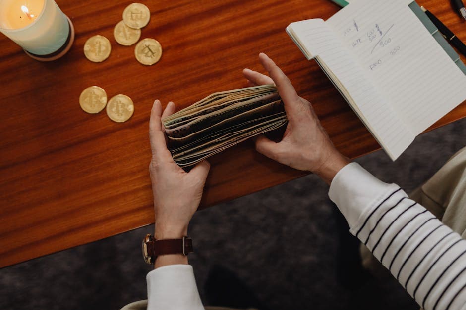 Close-up of a person organizing money with cryptocurrency coins on a wooden table, symbolizing modern finance.