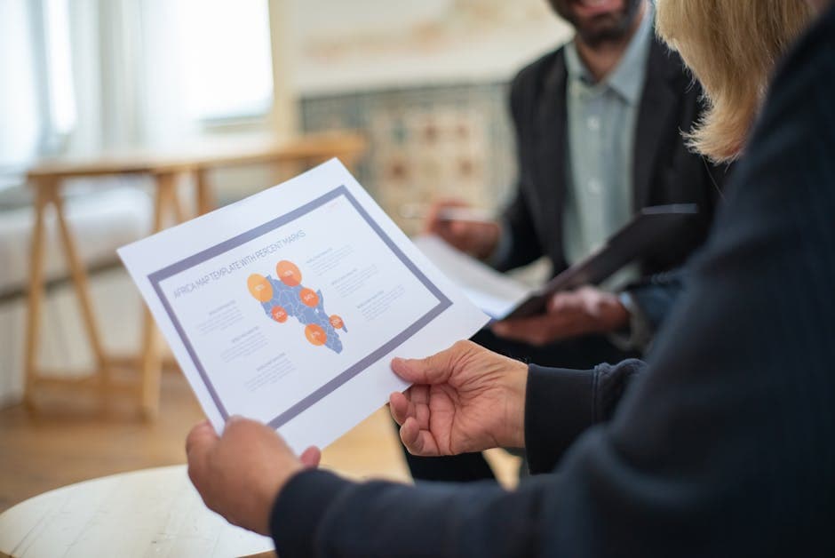 Three professionals discussing a data presentation in an office setting.