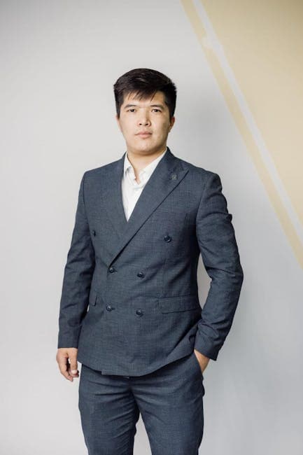A young businessman in a tailored suit exudes confidence and professionalism.